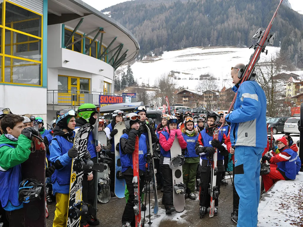 Jugendliche warten mit Snowboards vor der Talstation.